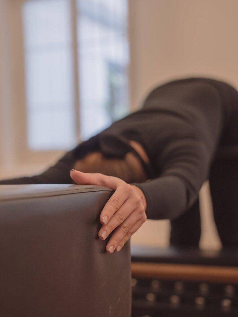 Manos apoyadas en el reformer durante un ejercicio suave, Pinar Pilates Madrid